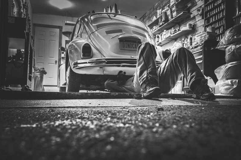 A mechanic working an old Volkswagen Beetle.
