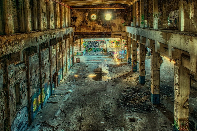 A photo of an old abandoned factory with graffiti on the walls.